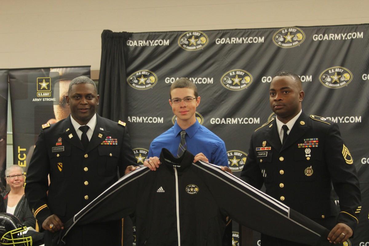 Representatives from the U.S. Army present senior Will Hinchliffe with a jacket at a presentation to announce his acceptance into the Army All-American Bowl Marching Band on Oct. 2. Hinchliffe is a trombone player in the West Henderson Flying Falcon Marching Band and has also participated in all-county, and all-district bands.
